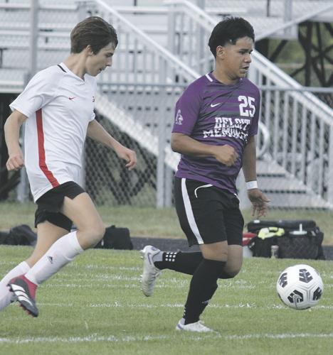  BMHS Soccer Player kicks soccer ball past opponet